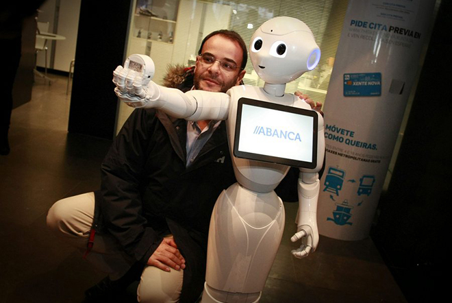 epa05675286 A man poses for a selfie with R4, installed in a Japanese humanoid robot called 'Pepper', at an office of Abanca in A Coruna, Spain, 14 December 2016. R4, who's software has been designed by the bank, is meant to help with commercial tasks in the office.  EPA/CABALAR
