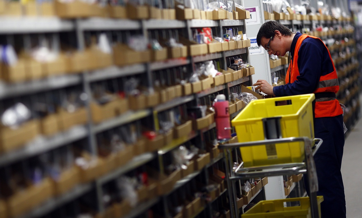 A worker collects items to pack into boxes at Amazon's logistics centre in Graben near Augsburg