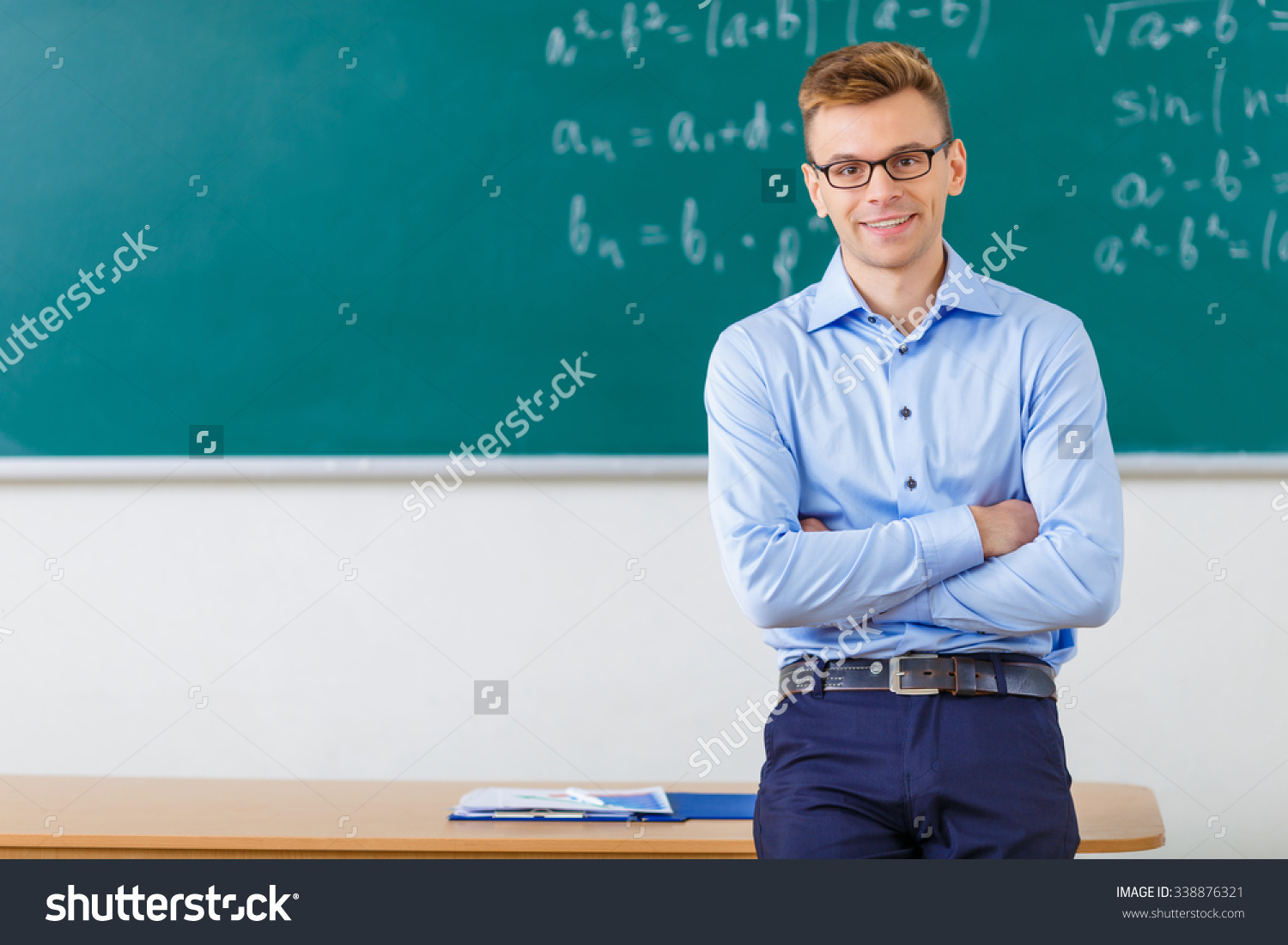 stock-photo-college-professor-handsome-young-college-professor-smiles-charmingly-while-folding-his-arms-and-338876321